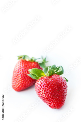 Two fresh strawberries were placed on a white background. Copy space
