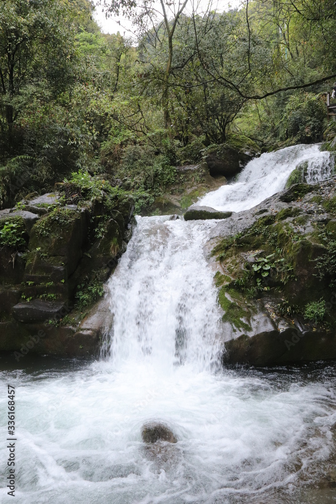 Naklejka premium Beautiful landscape of a waterfall in a forest in a Mountain in Sichuan, China