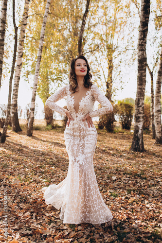 Beautiful bride in fashion wedding dress on natural background.The stunning young bride is incredibly happy. Wedding day. A beautiful bride portrait in the forest.