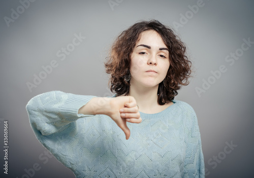Billede på lærred Closeup portrait angry mad upset pissed young woman, showing loser sign,  giving thumbs down isolated