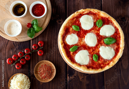 Traditional margarita pizza. Pizza with mozzarella, basil and tomatoes. Top view. Pizza sauce, cherry tomatoes, cheese