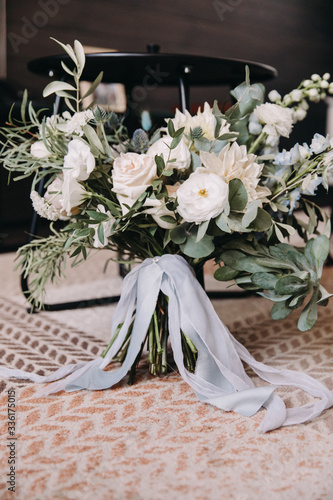 Wedding bridal bouquet of white flowers and greenery with silk ribbon