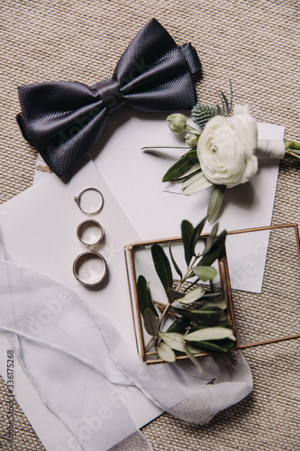 Wedding accessories. Wedding rings and buttonholes lie on invitation cards photo