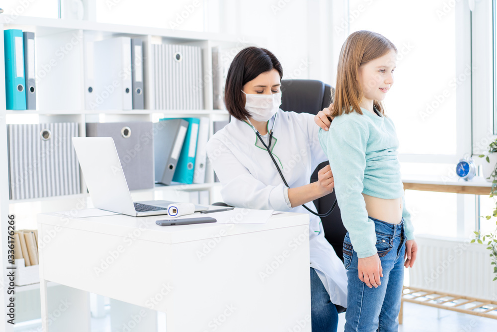 Fototapeta premium Nice doctor listening to little girl with phonendoscope