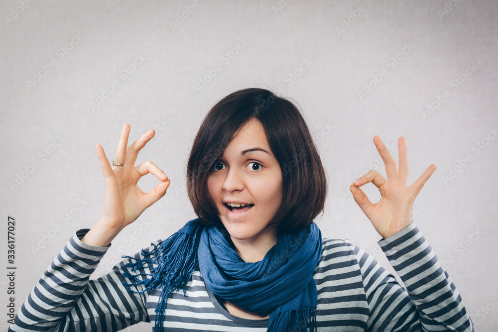 smiling young woman with fringes showing ok smiling young woman with fringes showing ok