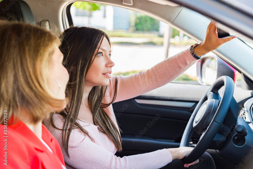 girl watches driver friend adjusts rearview mirror girl watches driver friend adjusts rearview mirror