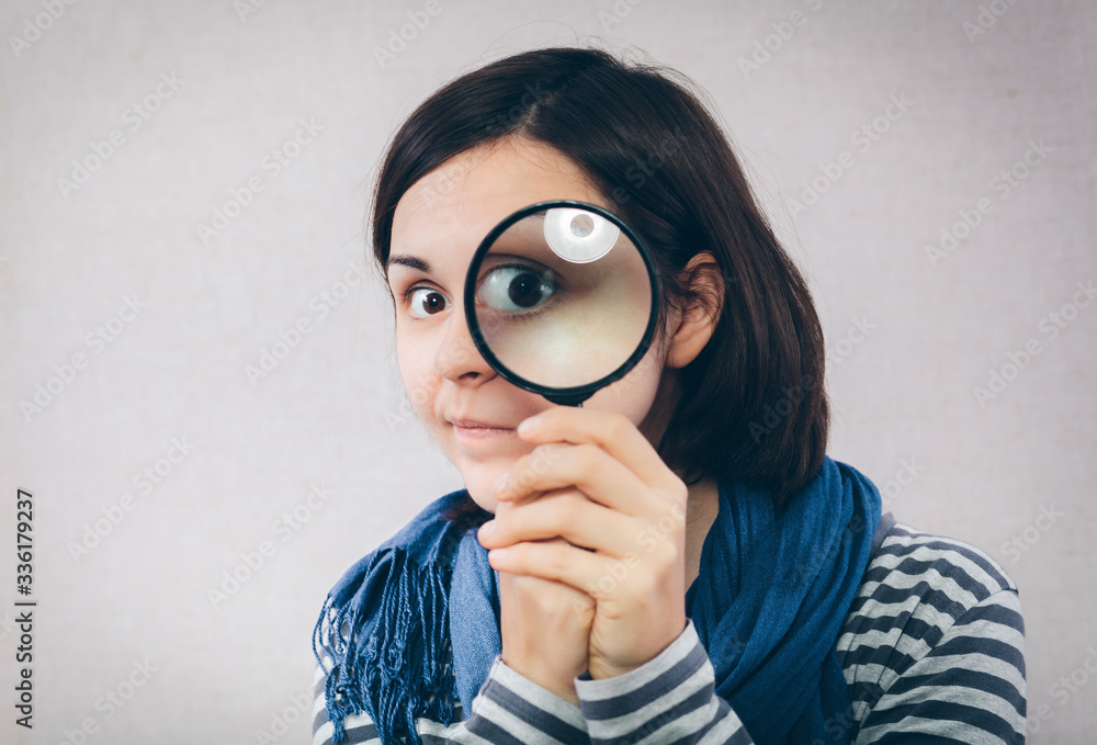 young girl looking through a magnifying glass young girl looking through a magnifying glass