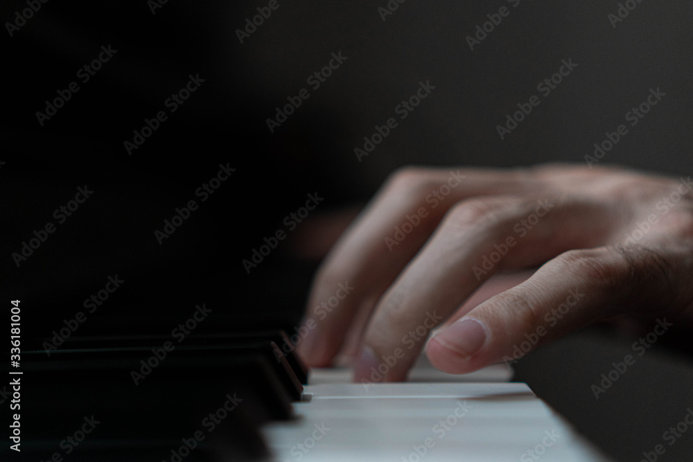Fototapeta premium hands of a man playing the piano during the day, stylish photo