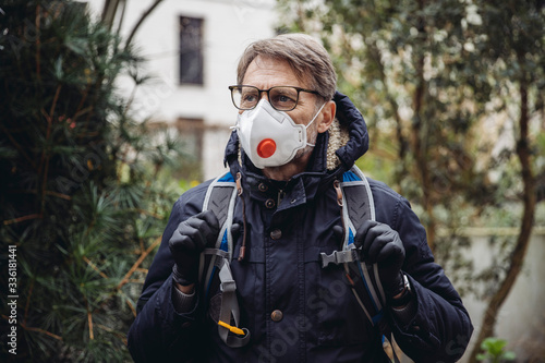 Matuer man commuting in the city, wearing protective mask photo