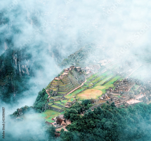 Aerial view of mountainious forested Machu Picchucovered with clouds photo