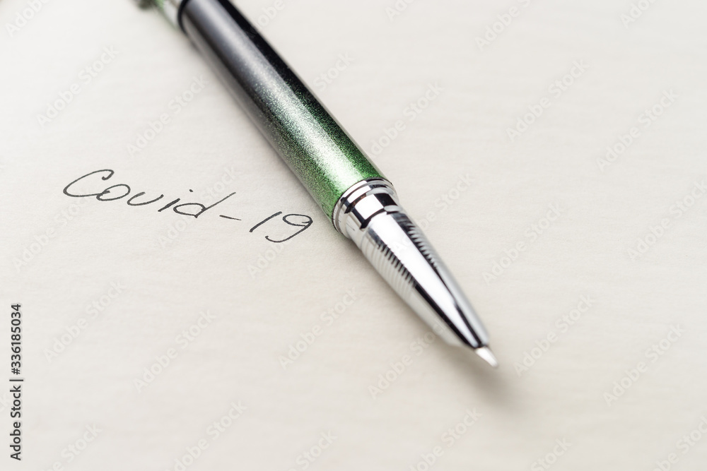 Covid-19 coronavirus inscription on a blank empty sheet of paper in a notebook. Nearby lies a pen. A lot of space for inscriptions and copyspace. Blank for inscriptions. Template for article or cover. Covid-19 coronavirus inscription on a blank empty sheet of paper in a notebook. Nearby lies a pen. A lot of space for inscriptions and copyspace. Blank for inscriptions. Template for article or cover.
