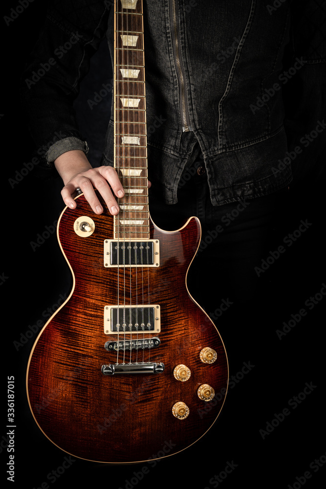 Fototapeta premium Eine rote E-Gitarre wird gehalten.