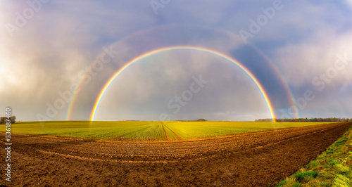 UK, Scotland, Panorama of double rainbow over agricultural field