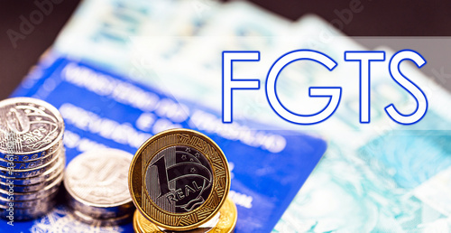 old work card from brazil, with coins and brazilian money, with the word FGTS. Concept of government benefits to the worker, withdrawal from the fgts or Brazilian MEI. photo
