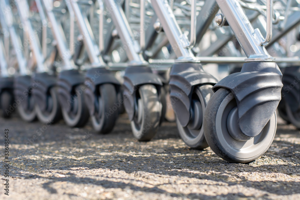 Modern supermarket shopping cart wheels in a row. Many rubber wheels of