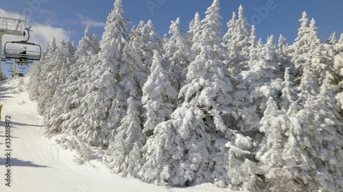view from chair lift on ski slope with trees covered with snow