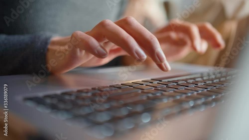 Close-up of female hands typing laptop keyboard. young woman using laptop photo