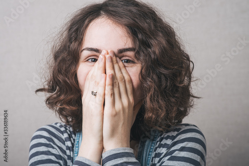 girl covers her face with her hands