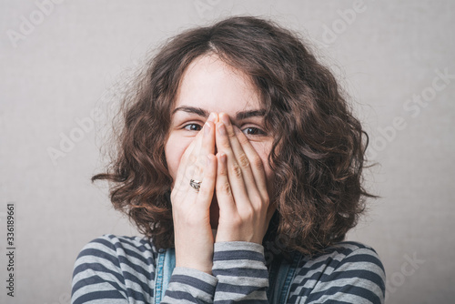 girl covers her face with her hands