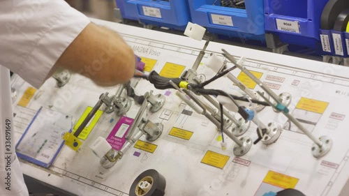 an employee winds up car wiring at a modern factory in a production shop. middle plan