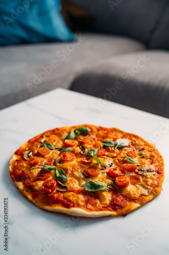 Delicious Pizza Margherita on white stone background. Homemade Pizza Margarita with Tomatoes, Basil and Mozzarella Cheese.Copy space, top view.