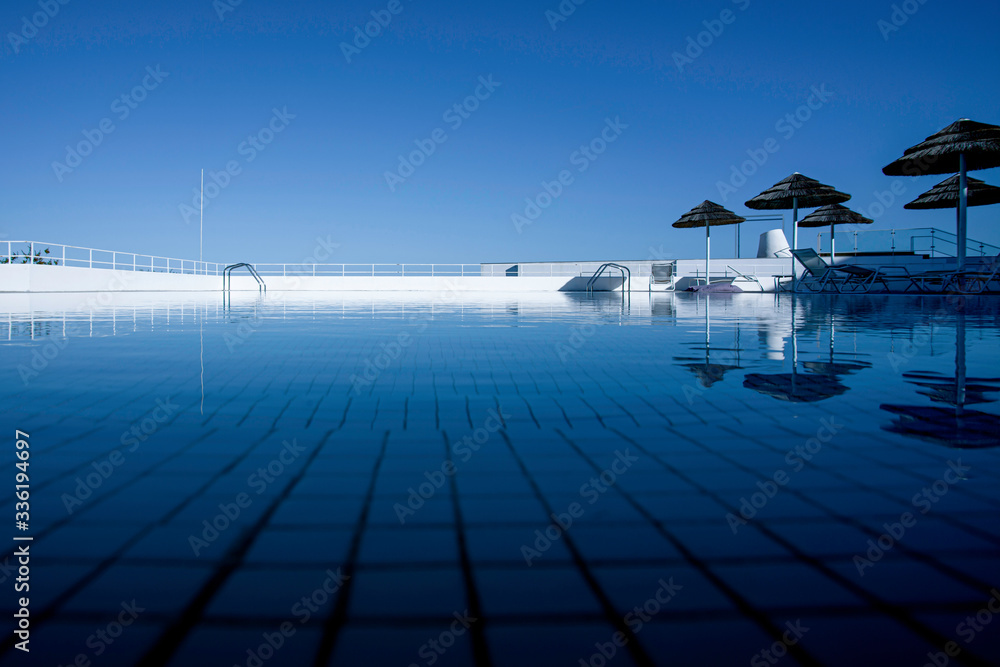 Swimming pool with blue sky reflection