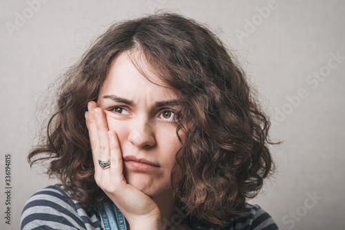 Woman toothache. Gray background