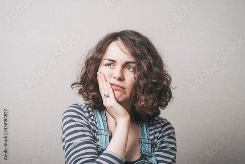 Woman toothache. Gray background
