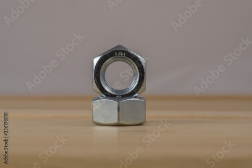 Dwie metalowe nakrętki ułożone jedna na drugiej