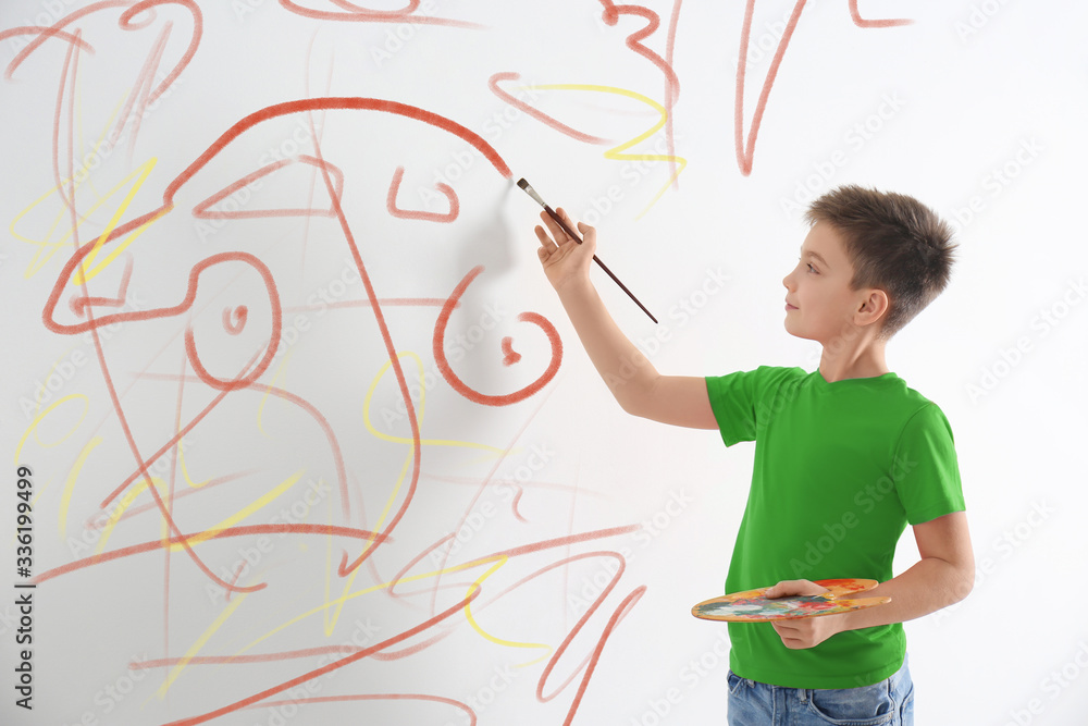 Little child drawing scribbles on white wall indoors Little child drawing scribbles on white wall indoors