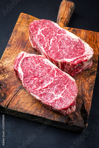 Raw dry aged wagyu entrecote beef steak roast as closeup on a rustic wooden cutting board