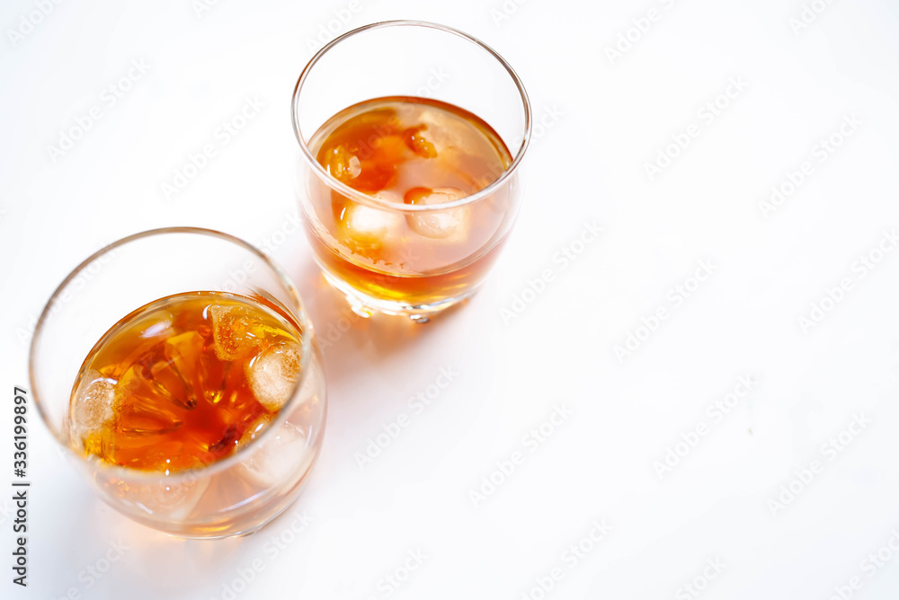 Two glasses with whiskey on a white background Two glasses with whiskey on a white background
