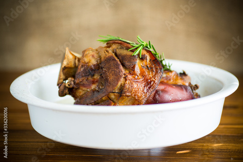 baked pork shank with spices in ceramic form