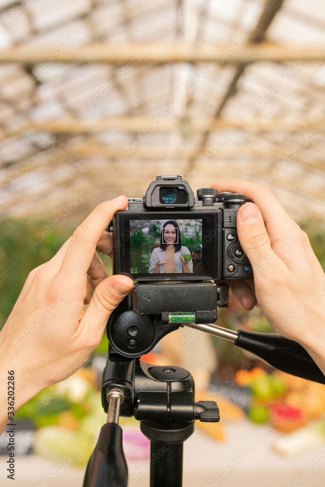 Obraz premium Close-up of unrecognizable camera operator preparing for shooting video review on farm products