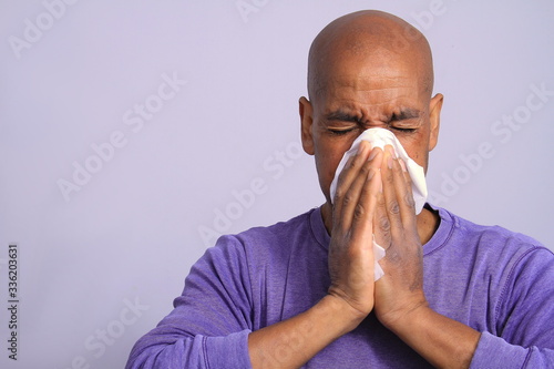 COVID-19 Coronavirus pandemic outbreak man with dust mask fighting the disease on grey background stock photo