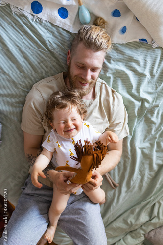 Dad Playing with his Baby Son in the Bed photo