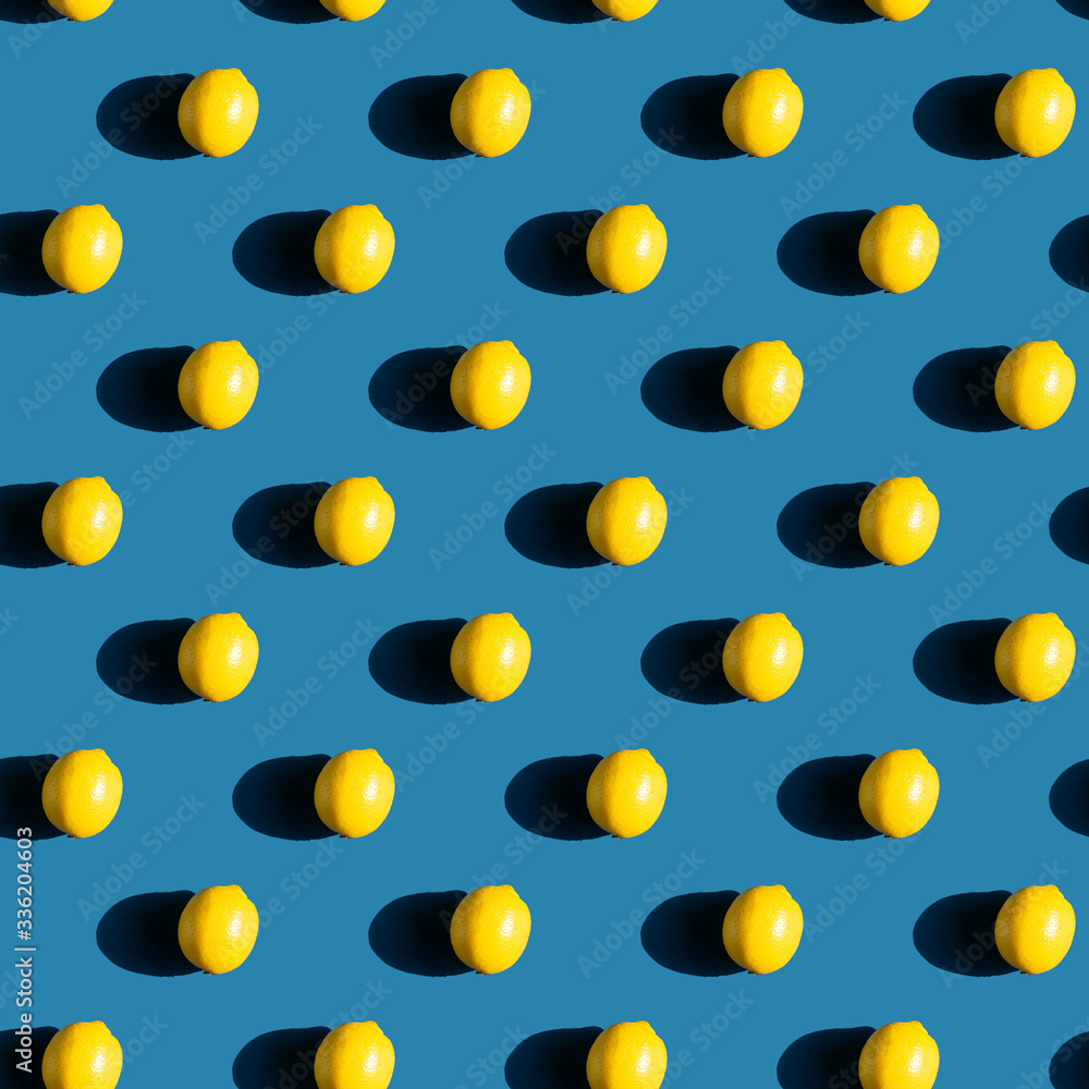 Repeating pattern of fresh lemons on blue background with natural sunlight and hard shadow
Repeating pattern of fresh lemons on blue background with natural sunlight and hard shadow