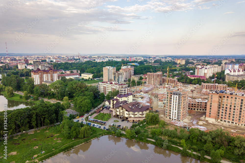 Top view of urban developing city landscape with tall apartment buildings and suburb houses. Drone aerial photography.