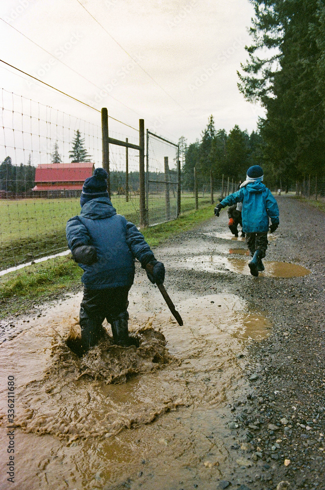 Wet kids walking through puddles in winter. Wet kids walking through puddles in winter.