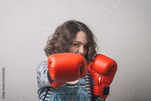 funny woman with boxing gloves, dressed in overalls