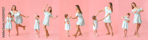 Happy mother and her little daughter dancing against color background