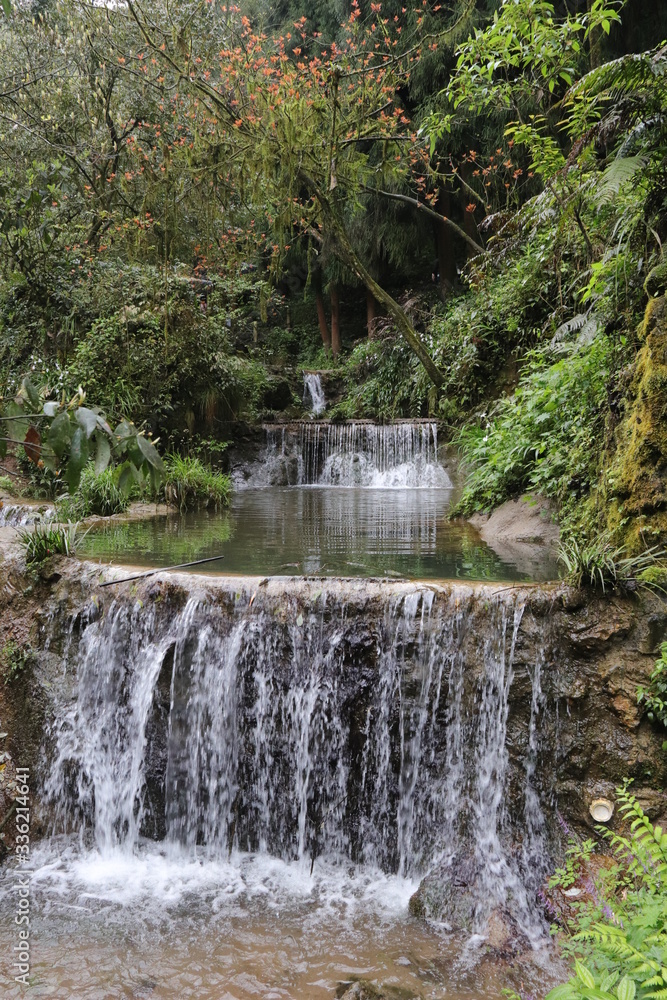 Beautiful landscape of cascade falls over mossy rocks, stones cover with moss, in a Mountain in Sichuan, China Beautiful landscape of cascade falls over mossy rocks, stones cover with moss, in a Mountain in Sichuan, China