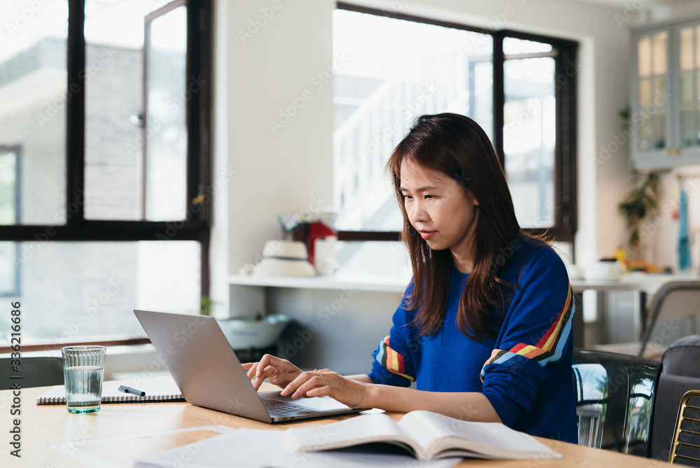 Young Asian woman working with computer at home Young Asian woman working with computer at home
