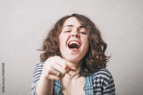 Photos funny cute brunette girl points finger and taunts