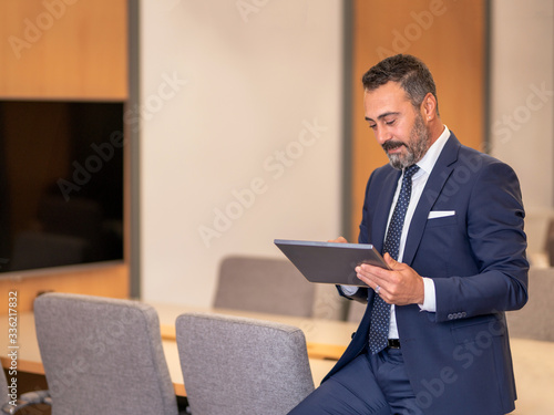 A smart-suited, bespectacled and saccid boss who controls both instant data and social media using his tablet as he wanders through the office