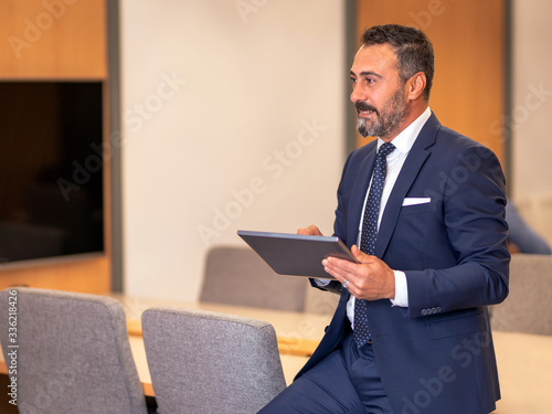 A smart-suited, bespectacled and saccid boss who controls both instant data and social media using his tablet as he wanders through the office