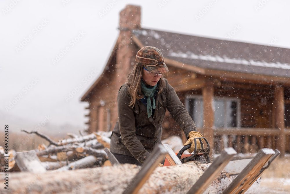 Ranch Manager and Cowgirl cutting wood with a chainsaw Ranch Manager and Cowgirl cutting wood with a chainsaw
