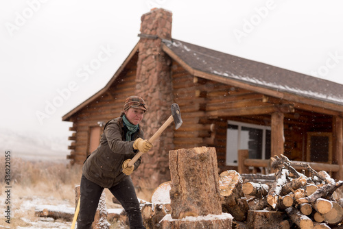 Ranch Manager and Cowgirl  cutting wood with a chainsaw photo