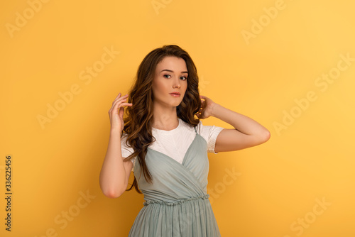 beautiful young spring woman with long hair on yellow