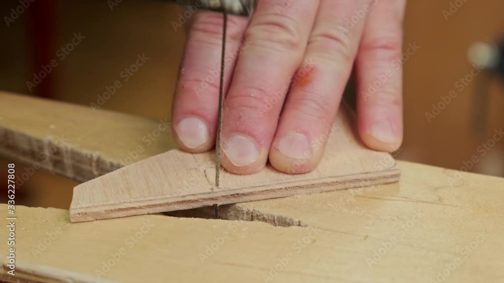skilled person hands cut plywood soviet airplane model detail with metal jigsaw on support extreme close view slow motion skilled person hands cut plywood soviet airplane model detail with metal jigsaw on support extreme close view slow motion
